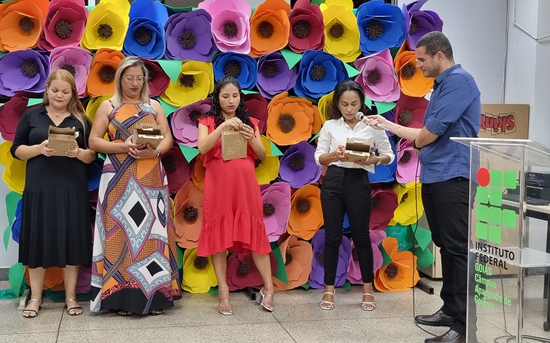 Momento em que alunas fazem homenagem a professores, servidores e familiares